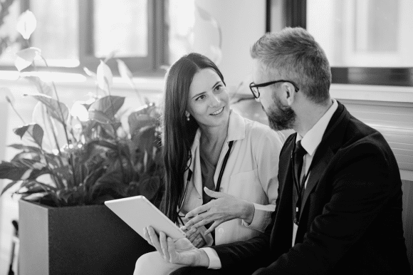 woman engaged in a conversation with a man holding a tablet